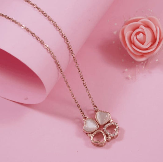 Elegant rose gold magnetic heart charm necklace with pink enamel and crystal accents against a soft pink background.