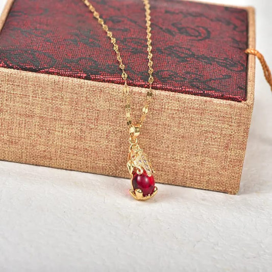 Elegant gold-plated red stone pendant necklace with a teardrop gemstone on gold chain.