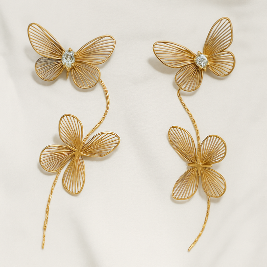 Elegant golden butterfly and clover statement earrings with sparkling crystal details.
