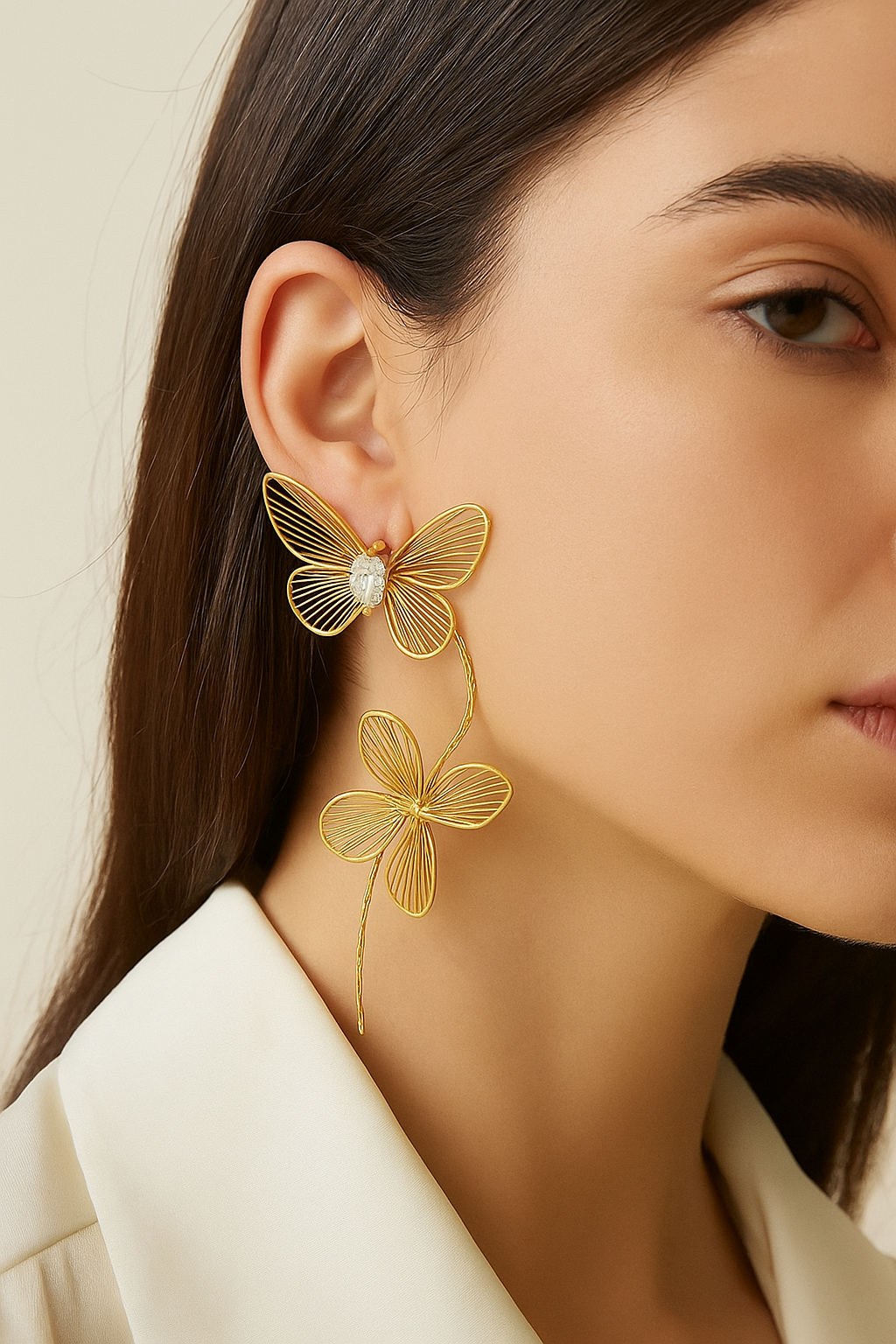 Golden butterfly and clover statement earrings on a model, showcasing elegant gold-tone wire and sparkling gemstone details.